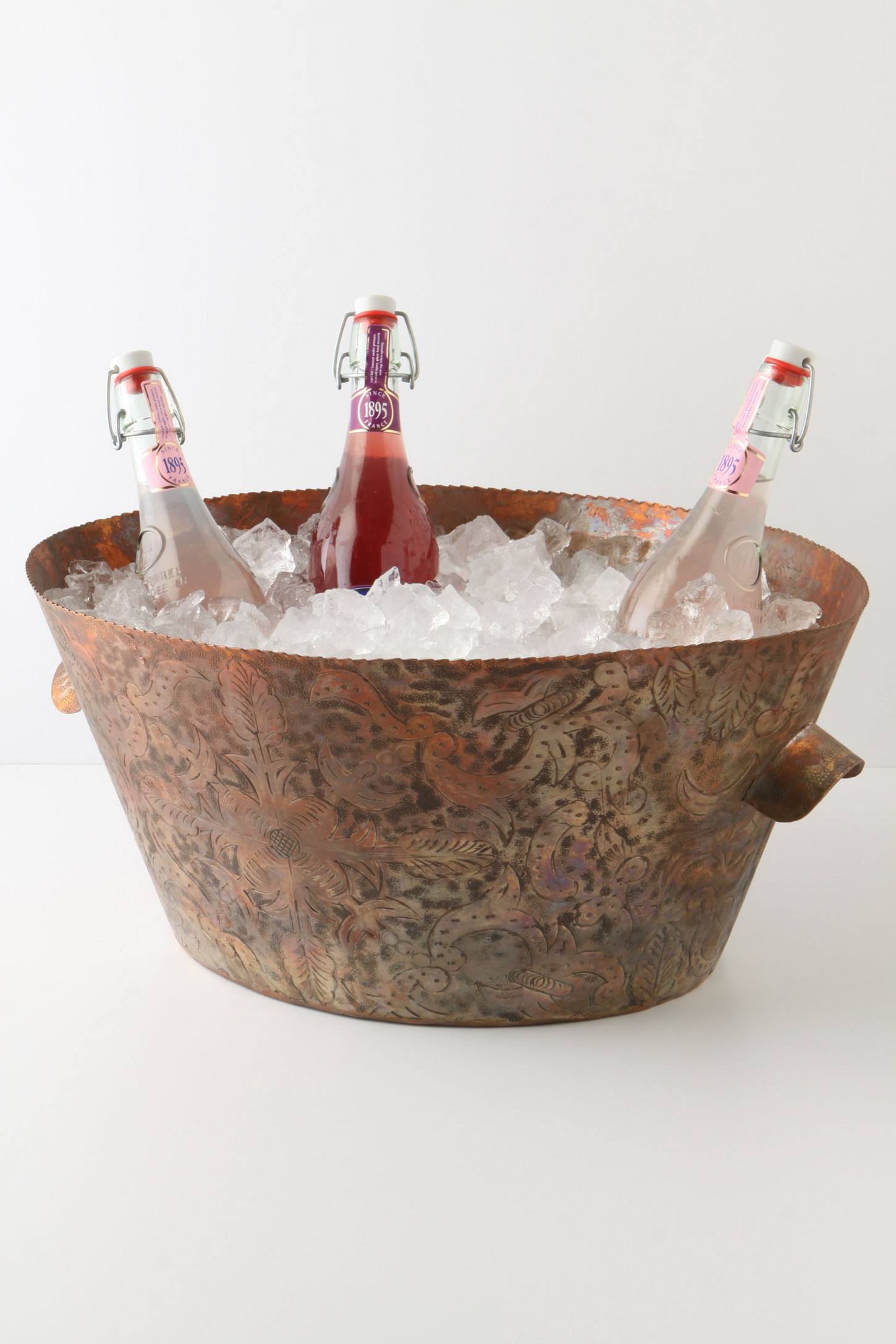 Copper party bucket with ice and three bottles in it